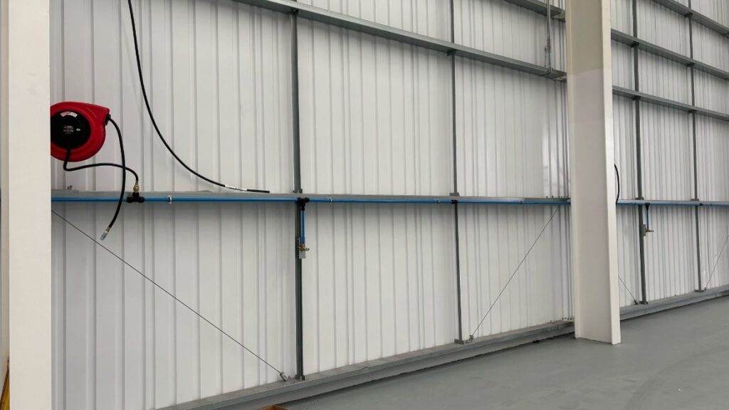 Compressed air aluminium ring main and hose reel drop installed along a factory wall — Captivair airline installation