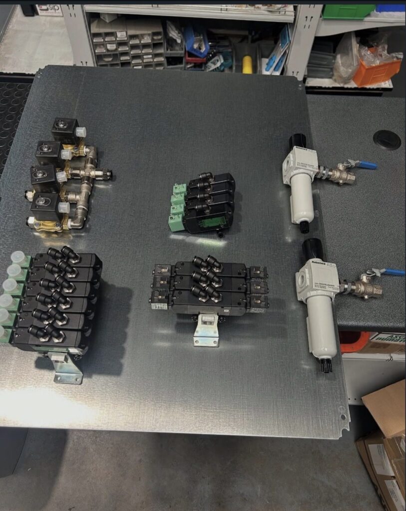 Pneumatic control panel components — Aventics valve banks, manifolds and FRL air treatment units before assembly
